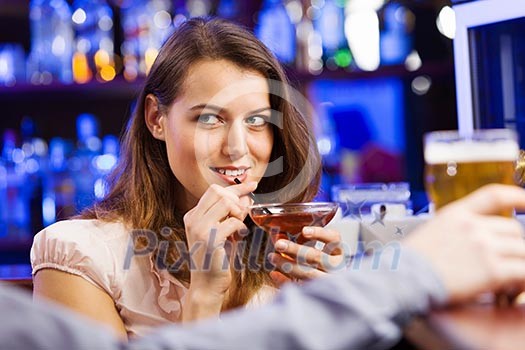 Young pretty girl at bar drinking cocktail Young pretty girl at bar drinking cocktail