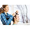 Young man in chair at barbers and woman hairdresser