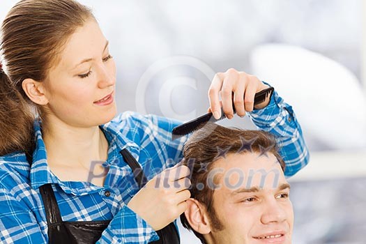 Young man in chair at barbers and woman hairdresser Young man in chair at barbers and woman hairdresser