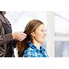 Young woman in chair at barbers and male hairdresser