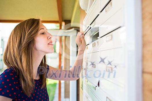 Pretty, young woman checking her mailbox for new letters Pretty, young woman checking her mailbox for new letters