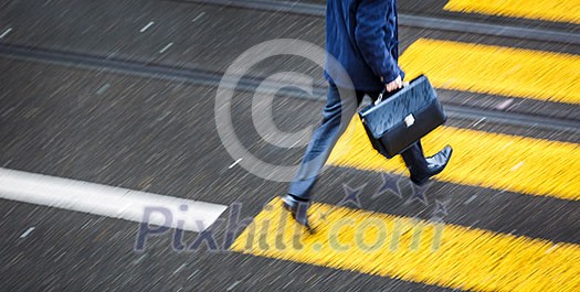 Man rushing over a road crossing in a city on a rainy day (motion blurred image) Man rushing over a road crossing in a city on a rainy day (motion blurred image)