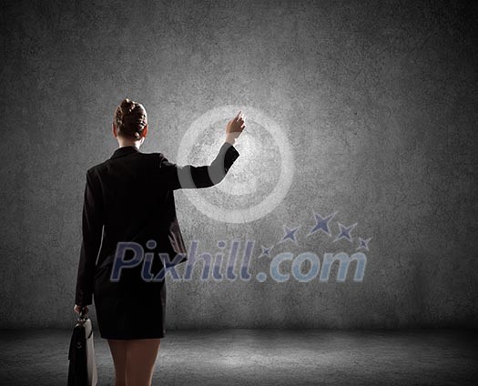 Rear view of businesswoman looking at blank cement wall Rear view of businesswoman looking at blank cement wall
