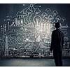 Rear view of businessman looking at chalk sketches on wall