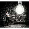 Young businesswoman with bulb and business sketches at background