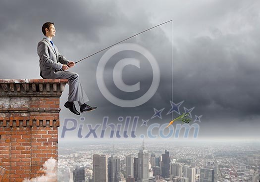 Businessman sitting on top of building and fishing with rod Businessman sitting on top of building and fishing with rod