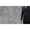 Close up of businessman body in suit against cement background