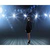 Rear view of businesswoman standing in lights of stage
