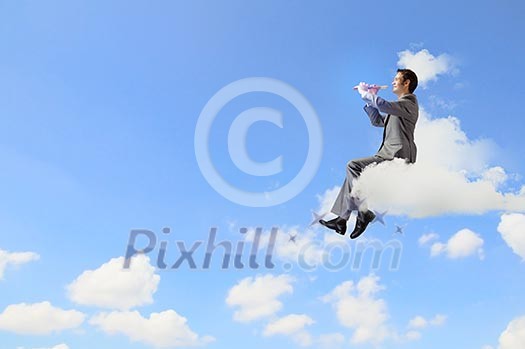 Young carefree businessman sitting on cloud and playing flute Young carefree businessman sitting on cloud and playing flute