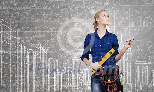 Young woman mechanic with ruler in hand against city background Young woman mechanic with ruler in hand against city background