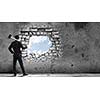 Young determined businessman with hammer in hands