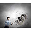 Young businessman crashing with hammer stone dollar symbol