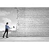Young determined businessman with hammer in hands