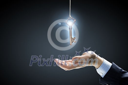 Close up of human hand holding key Close up of human hand holding key