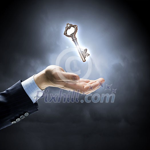 Close up of human hand holding key Close up of human hand holding key