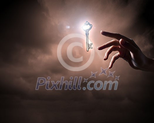 Close up of woman hand touching golden key Close up of woman hand touching golden key