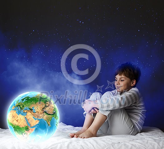 Cute boy sitting in bed and looking at Earth planet. Elements of this image are furnished by NASA