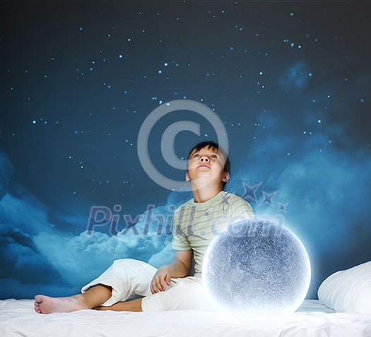 Cute boy sitting in bed with moon Cute boy sitting in bed with moon