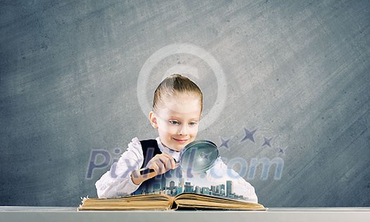 Schoolgirl examining opened book with magnifying glass Schoolgirl examining opened book with magnifying glass