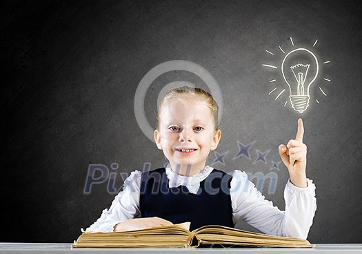Schoolgirl at lesson with opened book against sketch background Schoolgirl at lesson with opened book against sketch background