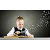 Schoolgirl examining opened book with magnifying glass