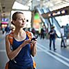 Pretty, young woman in a trainstation, waiting for her train, boarding a train (color toned image)