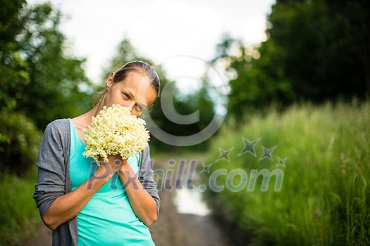 Young woman picking elderflower to make an infusion at home Young woman picking elderflower to make an infusion at home