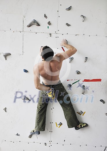 young and fit man exercise free mountain climbing on indoor practice wall young and fit man exercise free mountain climbing on indoor practice wall