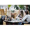 very cute smiling women drinking a coffee sitting inside in cafe restaurant