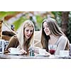 very cute smiling women drinking a coffee sitting inside in cafe restaurant