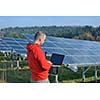 business man  engineer using laptop at solar panels plant eco energy field  in background