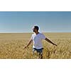 young man in wheat field representing success agriculture and freedom concept