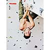 young and fit man exercise free mountain climbing on indoor practice wall