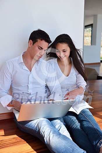 happy young relaxed couple working on laptop computer at modern home indoor happy young relaxed couple working on laptop computer at modern home indoor