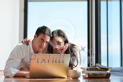 happy young relaxed couple working on laptop computer at modern home indoor happy young relaxed couple working on laptop computer at modern home indoor