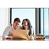 happy young relaxed  couple working on laptop computer at modern home indoor