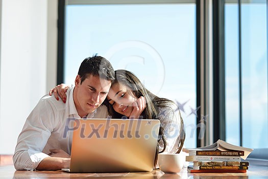 happy young relaxed couple working on laptop computer at modern home indoor happy young relaxed couple working on laptop computer at modern home indoor