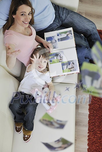 happy young family looking old pictures in photo album at home happy young family looking old pictures in photo album at home