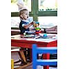 happy little child play game and have fun, education lessons in colorful kinder garden playground indoors