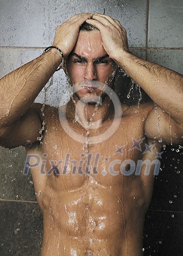 young good looking and attractive man with muscular body wet taking showe in bath with black tiles in background young good looking and attractive man with muscular body wet taking showe in bath with black tiles in background