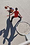 gorup of young boys who playing basketball outdoor on street with long shadows and bird view perspective