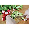 woman preparing healthy food salad with green and red vegetable and knife