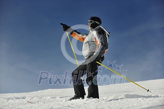 young man pointing direction on winter season during recration ski on mountain with show young man pointing direction on winter season during recration ski on mountain with show