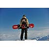 snowboarder relaxing and posing at sunny day on winter season with blue sky in background