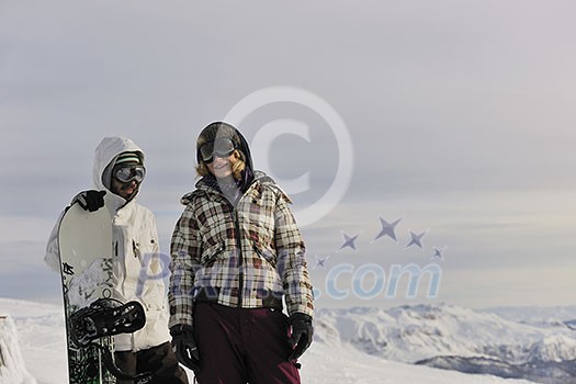 happy young snowboarder couple relax at top of mountain at beautiful sunny winter day happy young snowboarder couple relax at top of mountain at beautiful sunny winter day