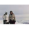 happy young snowboarder couple relax at top of mountain at beautiful sunny winter day