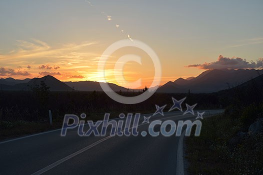 asphalt road through the green field and clouds on blue sky in summer day asphalt road through the green field and clouds on blue sky in summer day