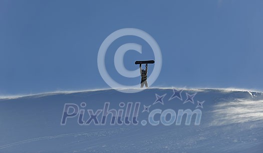 snowboarder relaxing and posing at sunny day on winter season with blue sky in background snowboarder relaxing and posing at sunny day on winter season with blue sky in background