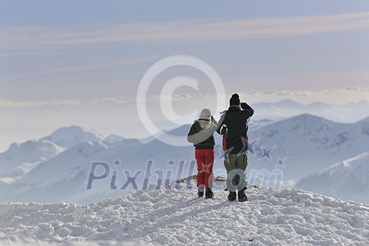 happy young snowboarder couple relax at top of mountain at beautiful sunny winter day happy young snowboarder couple relax at top of mountain at beautiful sunny winter day
