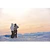 happy young snowboarder couple relax at top of mountain at beautiful sunny winter day